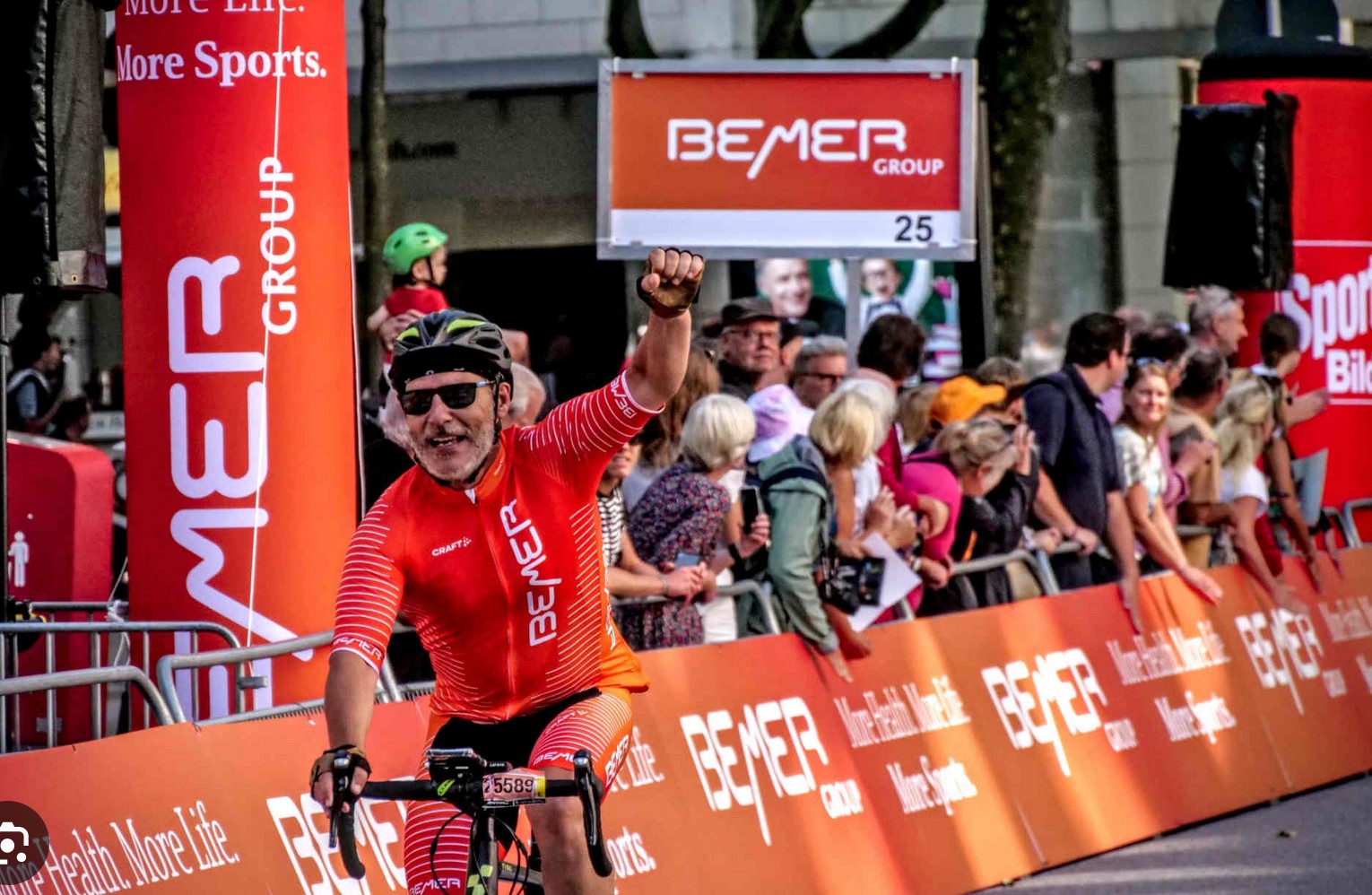Ciclista celebrando la meta en una carrera BEMER Group